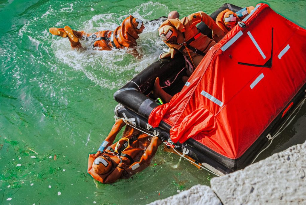 Dramatic rescue training scene with a team in orange suits and life raft.