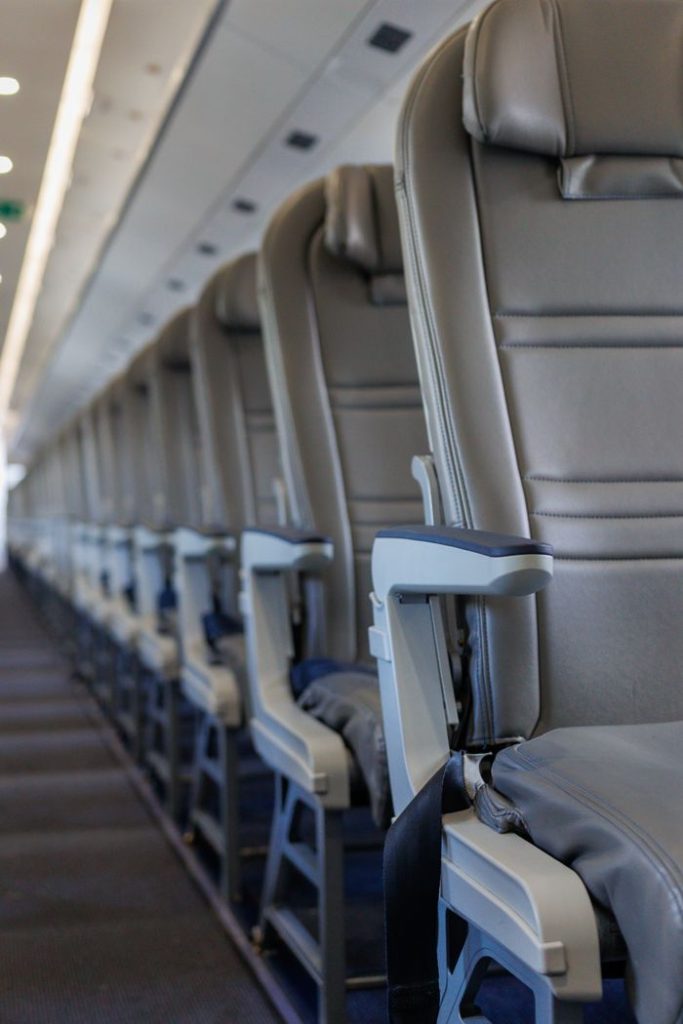 Interior view of an airplane cabin showcasing rows of empty seats, emphasizing travel and aviation themes.