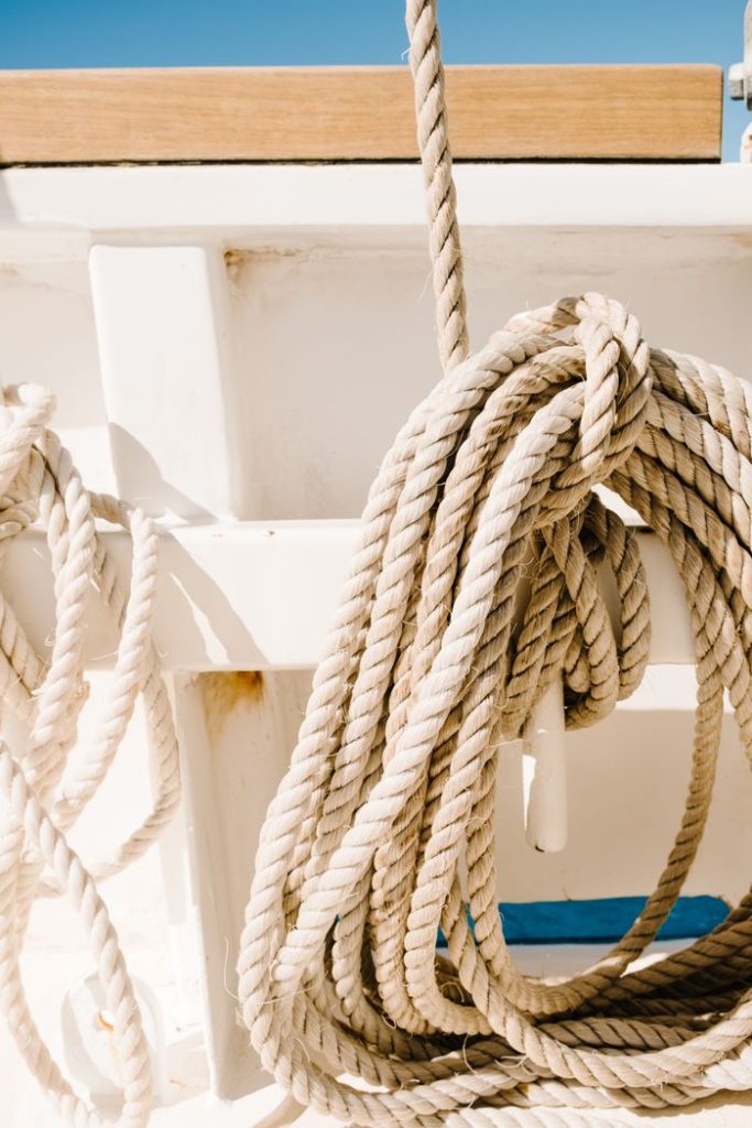 Detailed view of nautical ropes coiled on a boat deck under bright sunlight.